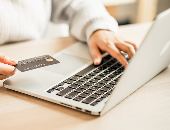 women using laptop computer shopping online pass credit card wit